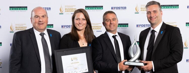 Four people holding a trophy and certificate at the Waikato Business Awards