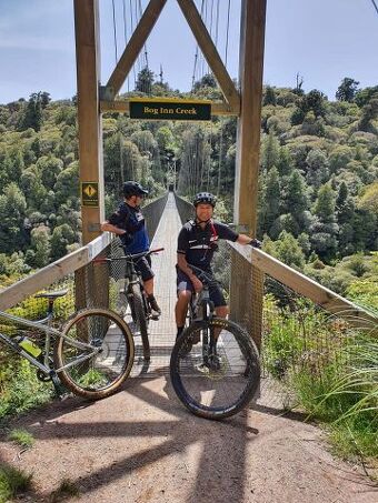 Two boys on mountain bikes at the Bog Inn Creek suspension bridge